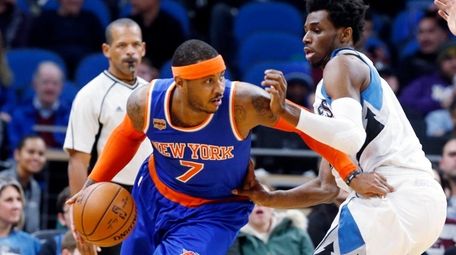 Carmelo Anthony drives past Andrew Wiggins of the