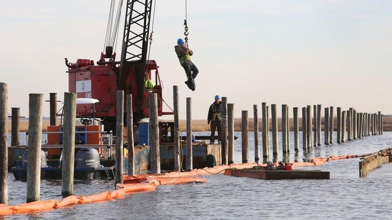 A contractor is hoisted to a small dock