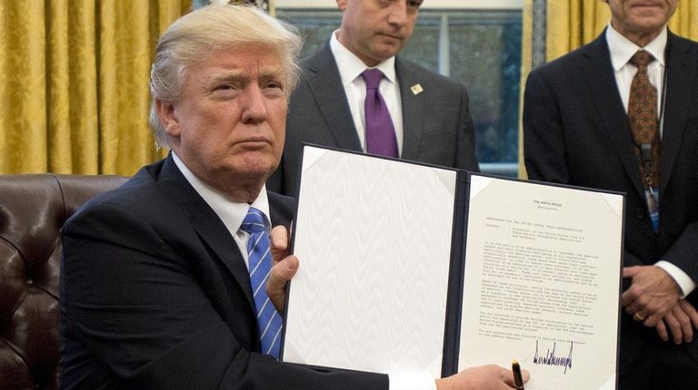 President Donald Trump shows the signed executive order