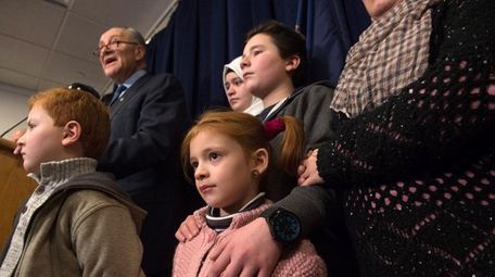 Sen. Charles Schumer stands with recently resettled refugees,