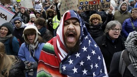 Izzy Berdan, center, wears an American flag as