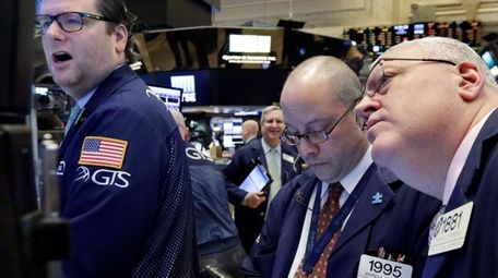 Specialist Gregg Maloney, left, works with traders Jeffrey