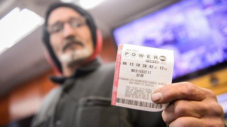 A customer holds a Powerball ticket at the