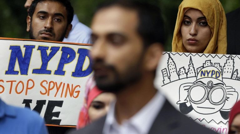 People hold signs while attending a rally to