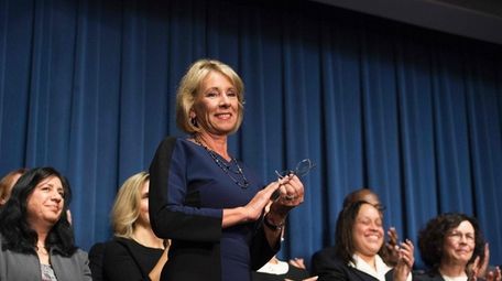 Secretary Betsy DeVos stands with her transition team