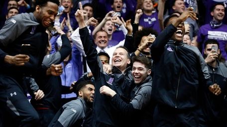 Northwestern coach Chris Collins, center, and players react