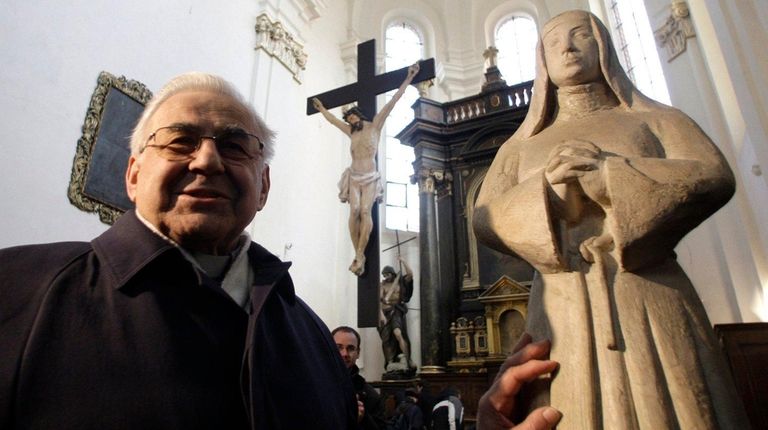 Cardinal Miloslav Vlk by a statue of St.