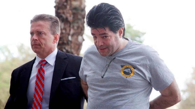 Aaron Wider, right, is escorted by a federal