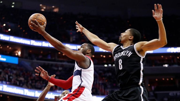 Washington Wizards guard John Wall, center, shoots between