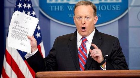 White House press secretary Sean Spicer holds up