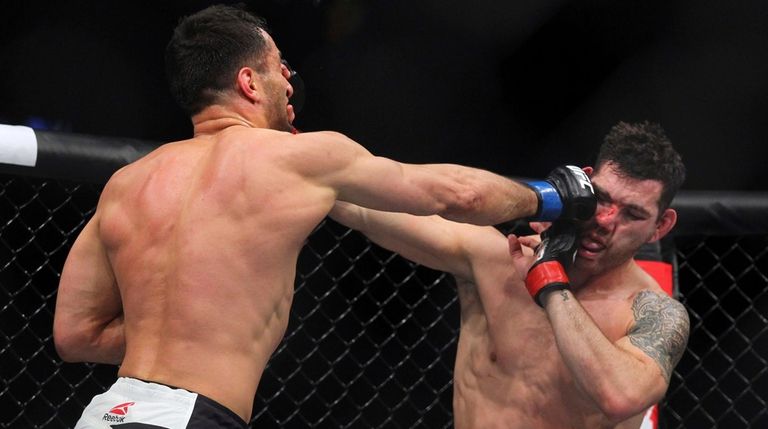 Gerard Mousasi, left, hits Chris Weidman during a