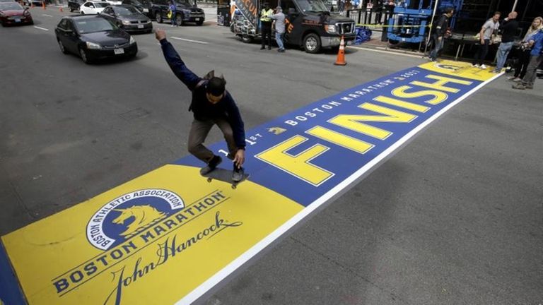 A skateboarder jumps over the newly applied Boston