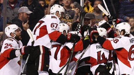 Members of the Ottawa Senators swarm Clarke MacArthur