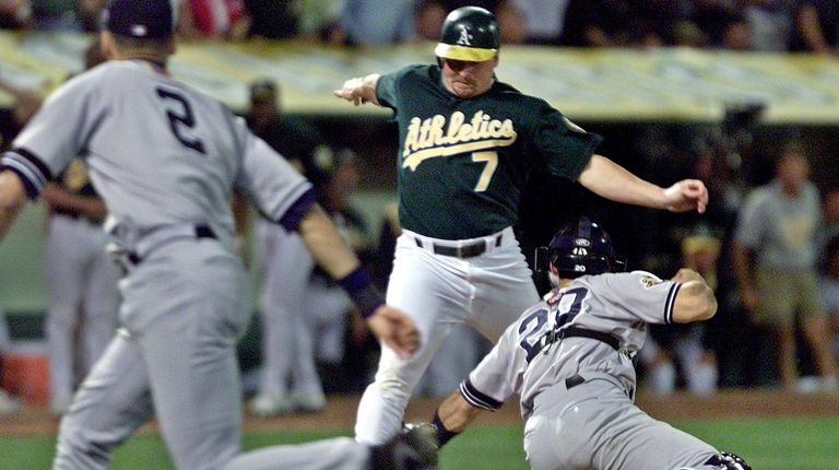 Oakland Athletics' Jeremy Giambi, center, is tagged out