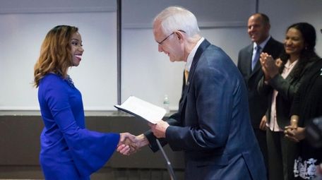 Renee Baptiste, of Roosevelt, accepts her diploma from