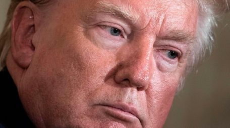 President Donald Trump listens during a press conference