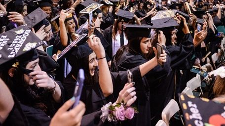 Graduates take selfies while switching their tassels as
