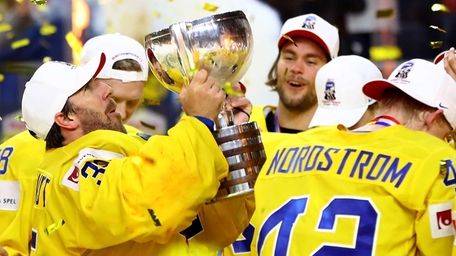 Henrik Lundqvist, goaltender of Sweden lifts the trophy