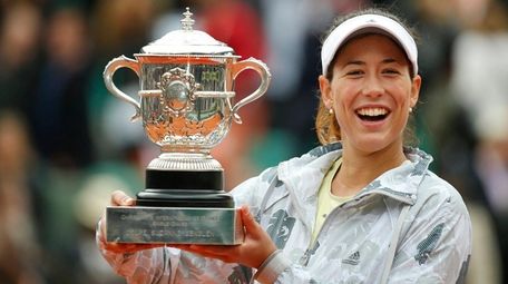 Garbine Muguruza holds the trophy after winning the