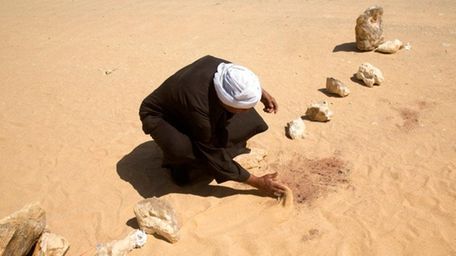 A man covers the blood stains of victims