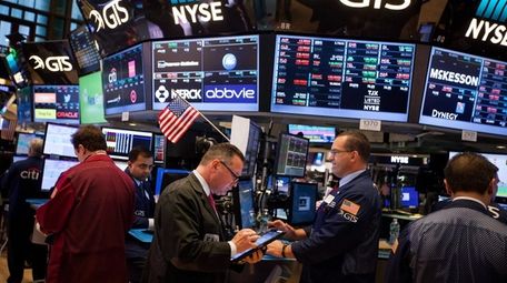 Traders work on the floor of the New