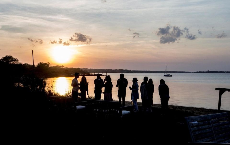 Friends watch as the sun sets overlooking Lake
