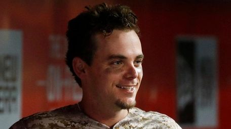 Cincinnati Reds' Scooter Gennett smiles in the dugout