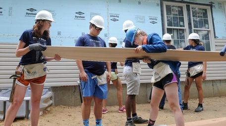 Habitat for humanity volunteers install siding on a