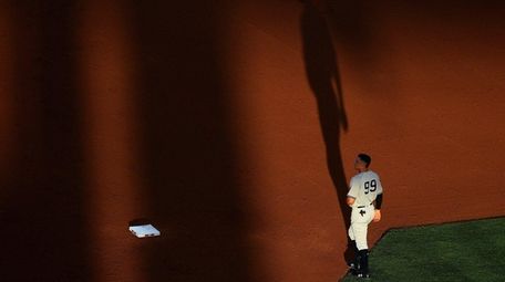 The Yankees' Aaron Judge walks to the outfield