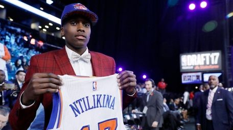 Frank Ntilikina holds up his jersey after being picked