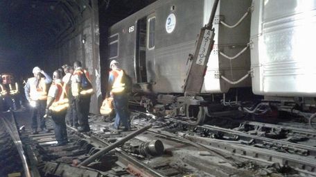 Workers examine damage at the West 125th Street