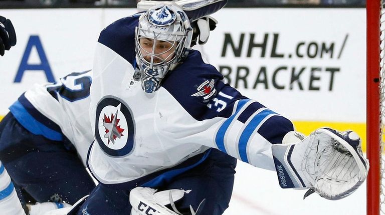 Jets goalie Ondrej Pavelec moves to make a