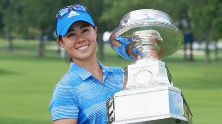 Danielle Kang poses with the trophy after winning