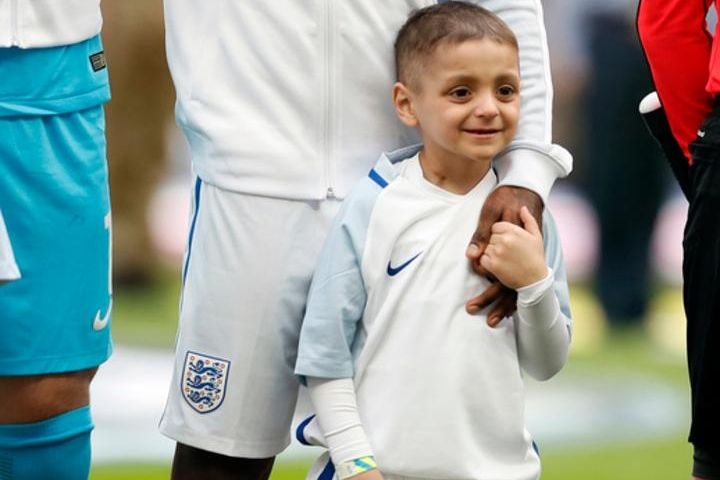 Bradley Lowery holds the hand of England's Jermain