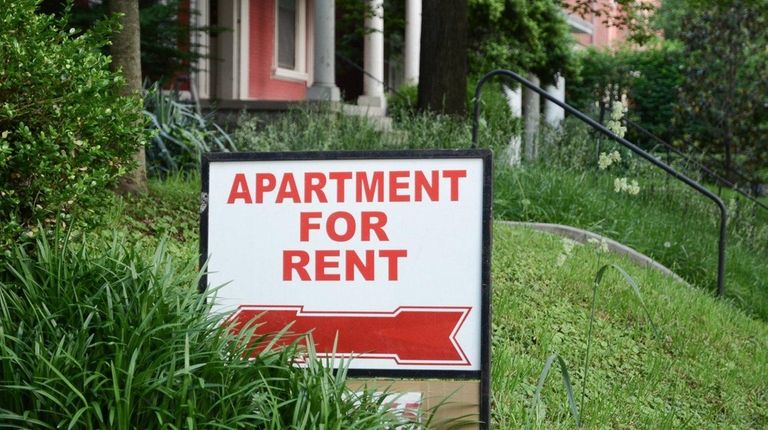 Apartment for rent sign displayed on residential street.