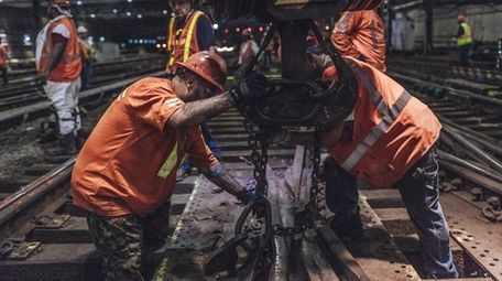 Amtrak crews lift old sections of track