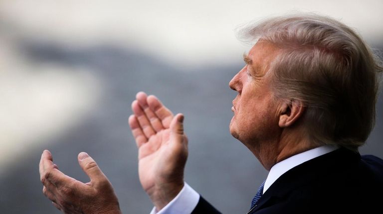 President Donald Trump applauds as he attends the