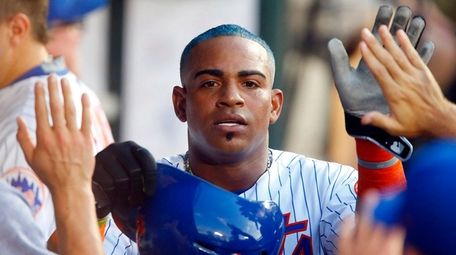Yoenis Cespedes of the Mets celebrates in the dugout against