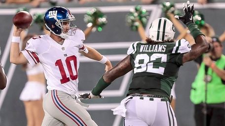 Giants quarterback Eli Manning attempts a pass on