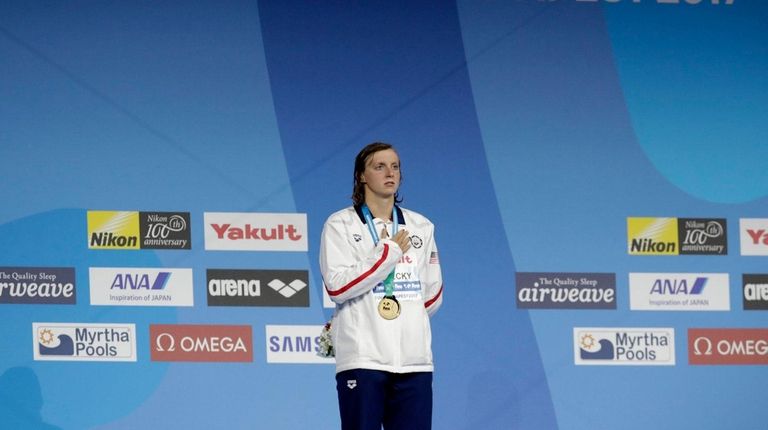 United States' gold medal winner Katie Ledecky listens