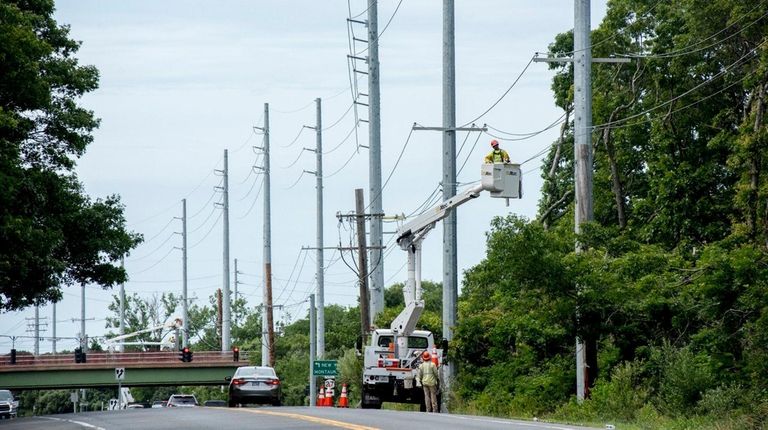 Contractors work on new PSEG poles that were