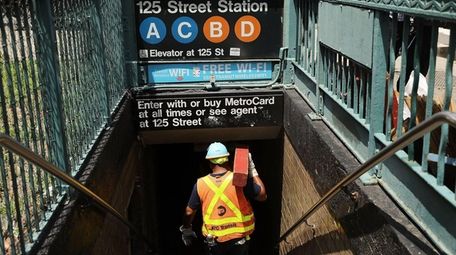 An MTA worker enters a Harlem subway