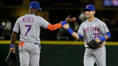 The Mets' Michael Conforto, right, greets Jose Reyes