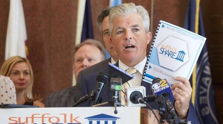 Suffolk County Executive Steve Bellone holds up a