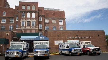 Ambulances are seen parked at the entrance to