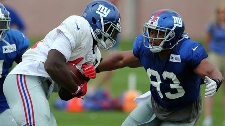 Giants linebacker B.J. Goodson , right, catches up with