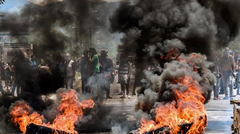 Anti-government activists stand near a barricade Sunday in