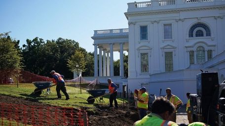 Workers on the lawn outside of the Brady