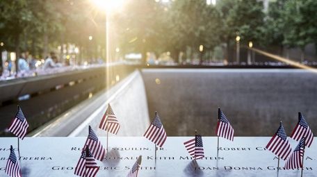 American flags are placed on the 9/11 Memorial