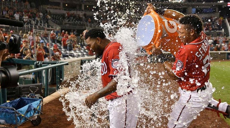 Washington Nationals' Pedro Severino, right, douses Howie Kendrick,